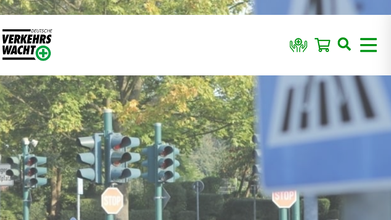 Verkehrssignale und Straßenschilder vor grünem Bewuchs im Hintergrund